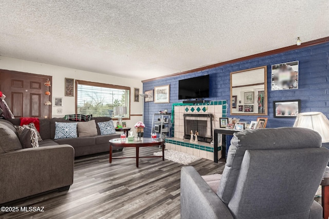 living area featuring a fireplace, a textured ceiling, and wood finished floors