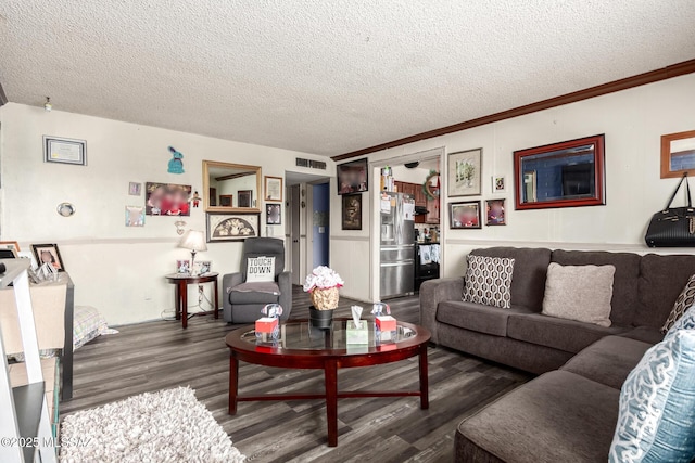 living room featuring visible vents, a textured ceiling, and wood finished floors