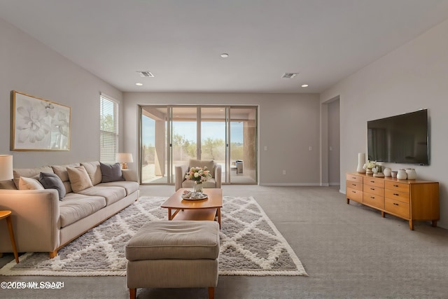 living room featuring visible vents, plenty of natural light, and light carpet