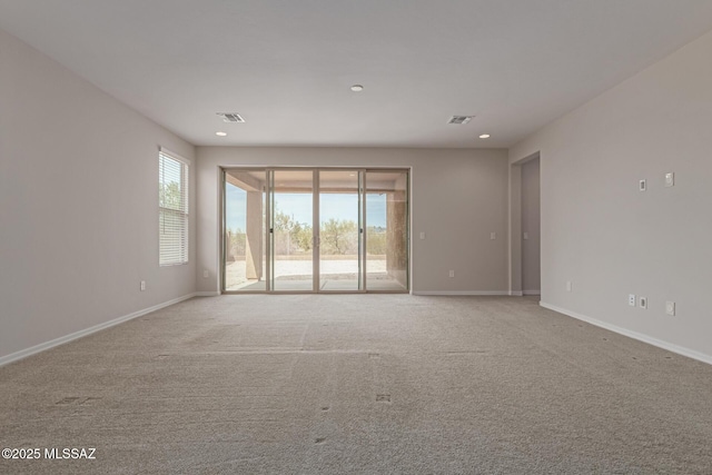 unfurnished room featuring visible vents, plenty of natural light, and baseboards