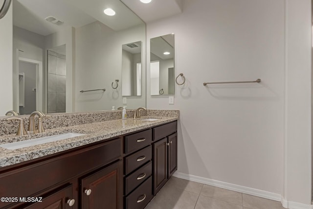 bathroom with tile patterned flooring, visible vents, a sink, and baseboards