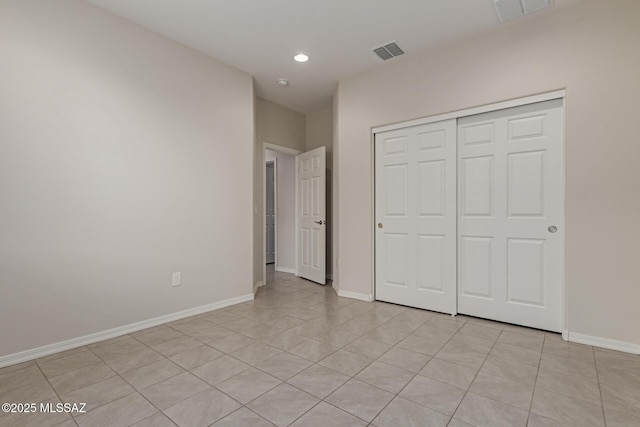 unfurnished bedroom with baseboards, visible vents, and a closet