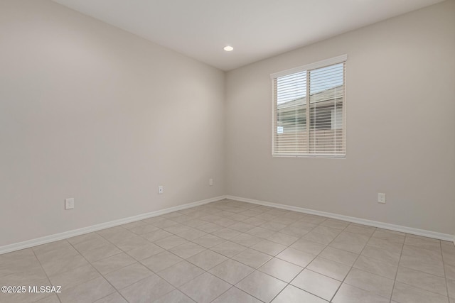 spare room with recessed lighting and baseboards