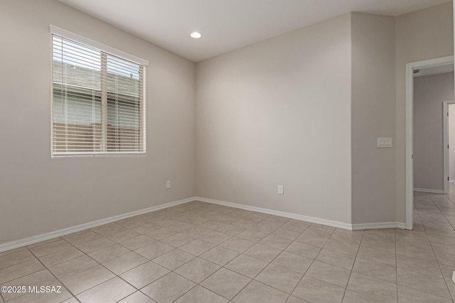 spare room featuring light tile patterned floors, recessed lighting, and baseboards