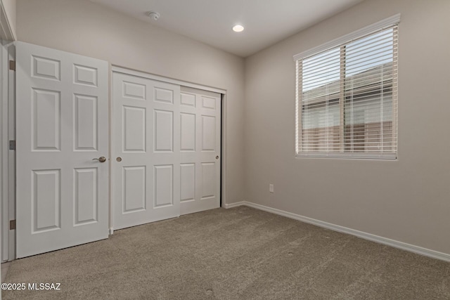 unfurnished bedroom with carpet, baseboards, and a closet