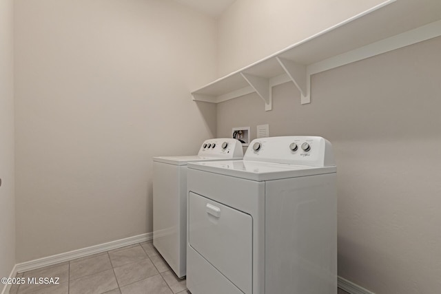 laundry area featuring washer and dryer, laundry area, baseboards, and light tile patterned floors