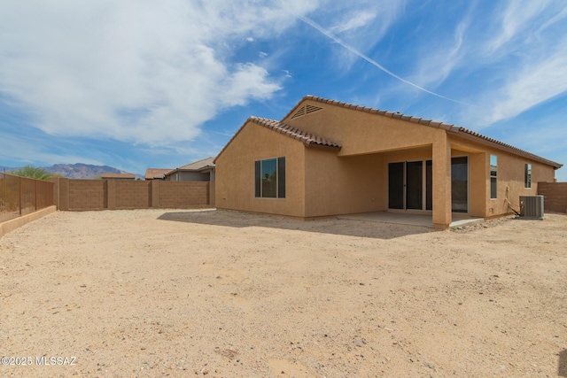 back of house with central air condition unit, a fenced backyard, a patio, and stucco siding