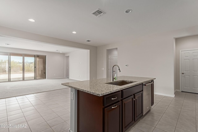 kitchen featuring light stone counters, visible vents, a sink, and light tile patterned floors