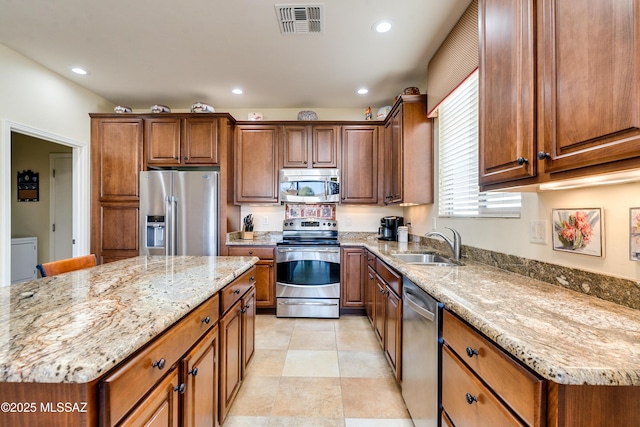 kitchen featuring recessed lighting, stainless steel appliances, a sink, visible vents, and light stone countertops