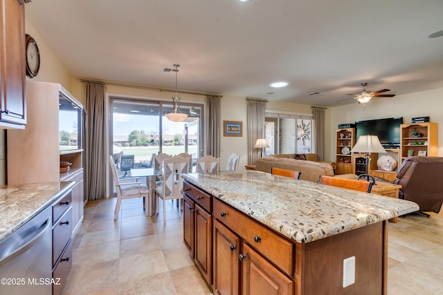 kitchen featuring dishwasher, light stone counters, brown cabinets, open floor plan, and hanging light fixtures