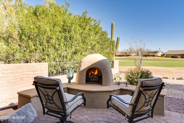 view of patio / terrace featuring a warm lit fireplace