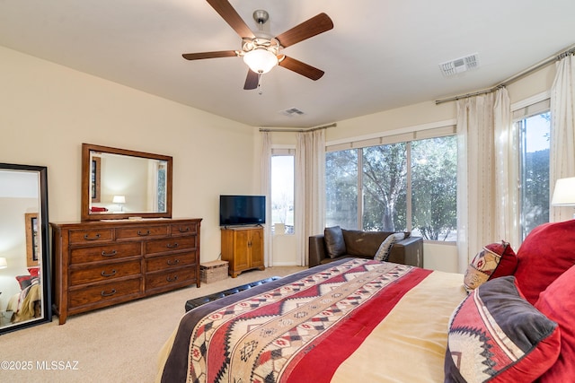 carpeted bedroom featuring ceiling fan, multiple windows, and visible vents