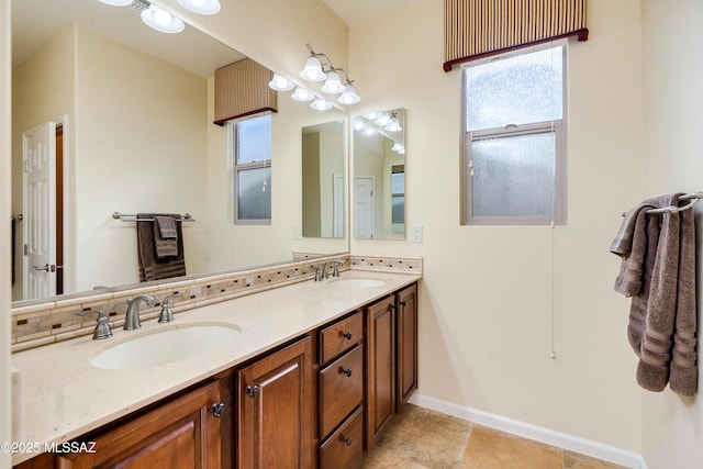 bathroom featuring double vanity, a sink, and baseboards