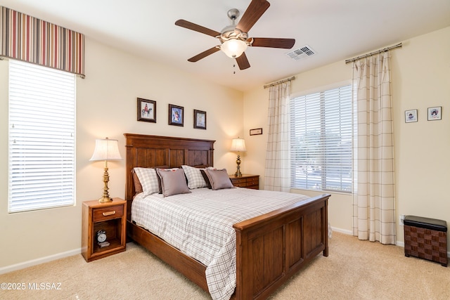 bedroom with visible vents, light carpet, and baseboards