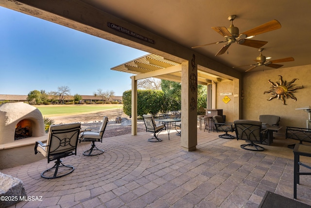 view of patio with outdoor dining space, a pergola, ceiling fan, and an outdoor fireplace