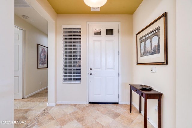 foyer entrance with visible vents and baseboards