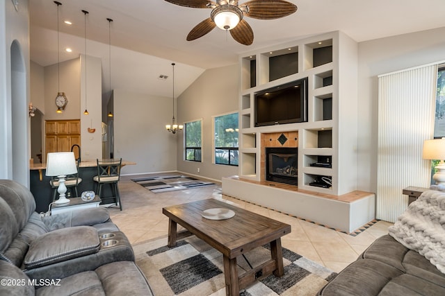 living area featuring high vaulted ceiling, ceiling fan with notable chandelier, built in features, light tile patterned floors, and baseboards