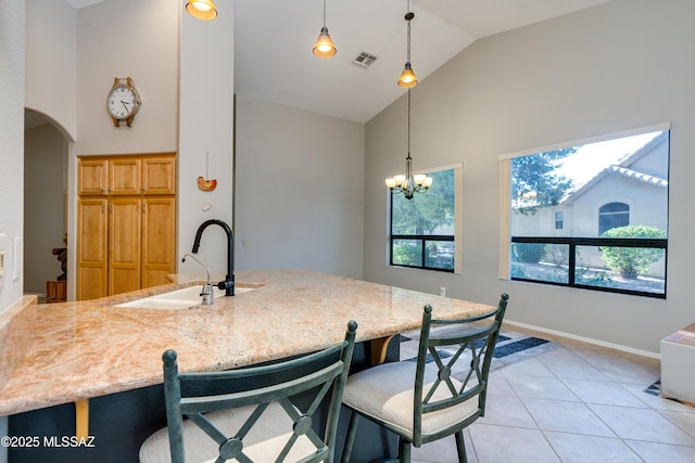 kitchen featuring hanging light fixtures, visible vents, high vaulted ceiling, and a sink