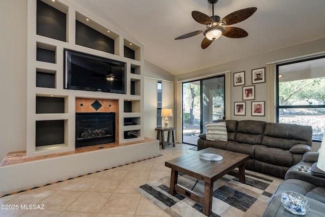 living room with light tile patterned floors, built in shelves, a wealth of natural light, and a ceiling fan