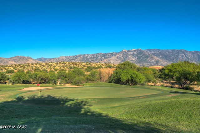 view of home's community featuring golf course view, a lawn, and a mountain view