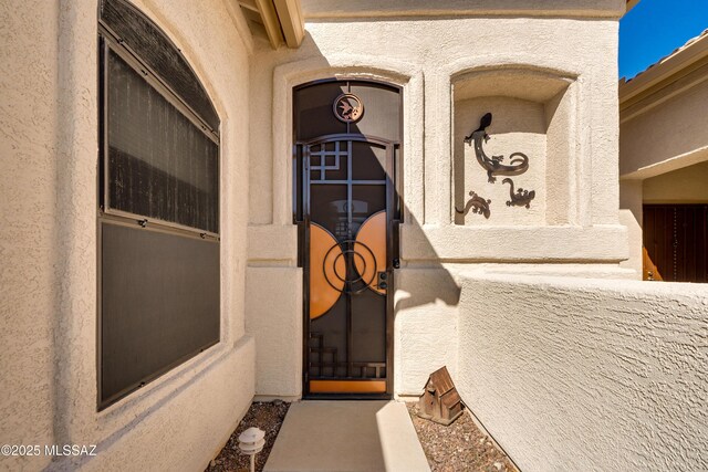 doorway to property featuring stucco siding