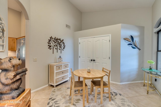 dining room with arched walkways, visible vents, baseboards, and light tile patterned flooring