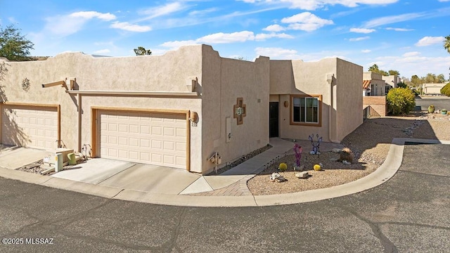 southwest-style home featuring a garage, driveway, and stucco siding