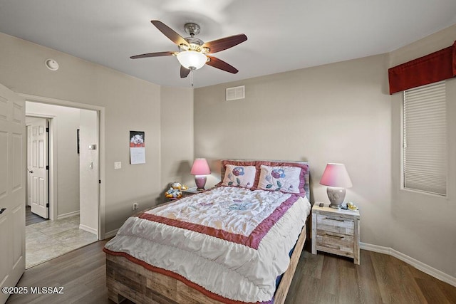 bedroom with wood finished floors, visible vents, a ceiling fan, and baseboards