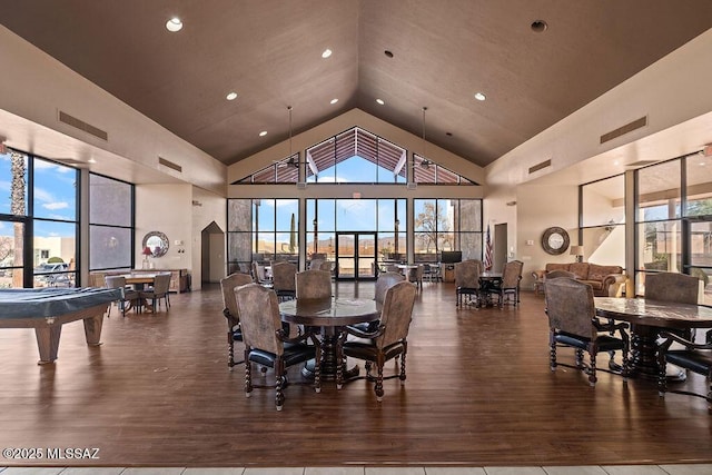 dining room with visible vents, wood finished floors, and high vaulted ceiling