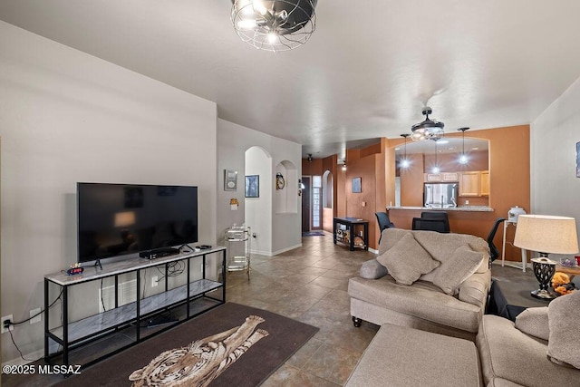 living area with baseboards and arched walkways