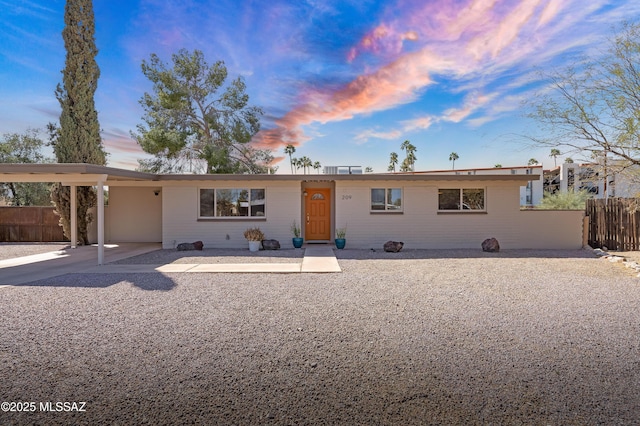 ranch-style house with an attached carport and fence