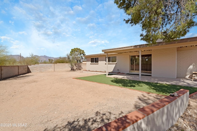 view of yard featuring a patio area, a fenced backyard, and a mountain view