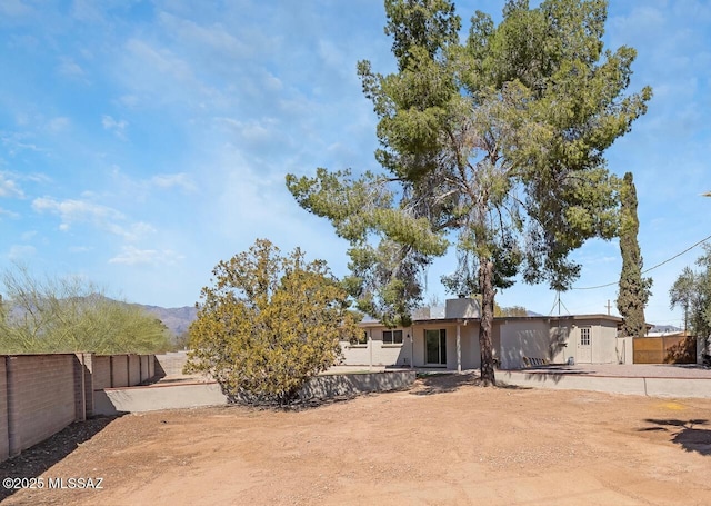 view of front of property with fence and a patio