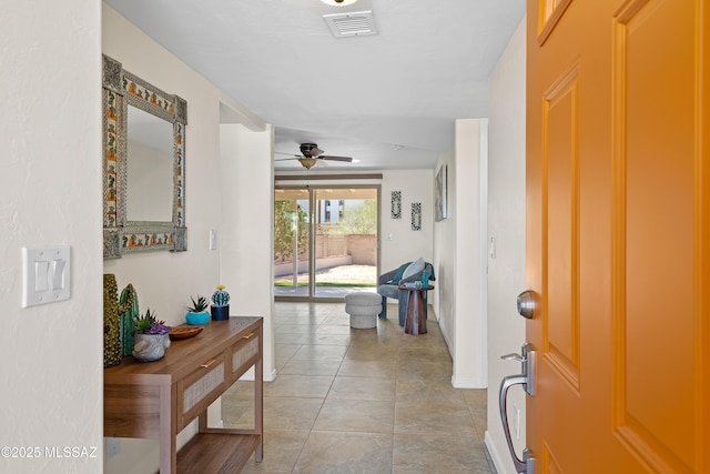 hallway featuring visible vents and light tile patterned flooring