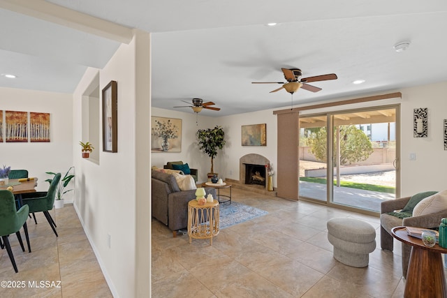 living area with recessed lighting, a fireplace with raised hearth, baseboards, and light tile patterned floors