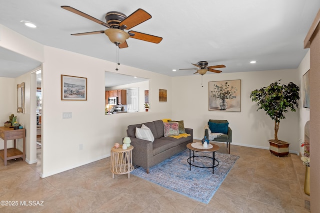 living area with a ceiling fan, recessed lighting, and baseboards