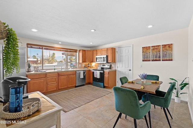 kitchen featuring stainless steel appliances, recessed lighting, light countertops, and a sink