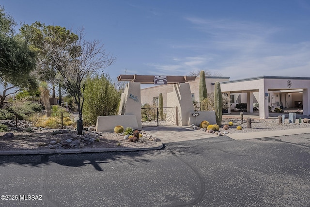 view of front of house with a gate, fence, and stucco siding