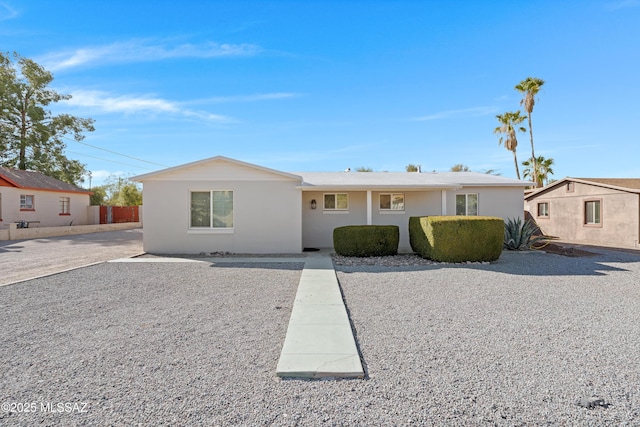 ranch-style house with fence and stucco siding