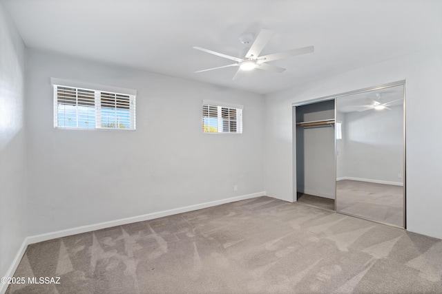 unfurnished bedroom featuring ceiling fan, a closet, baseboards, and carpet flooring