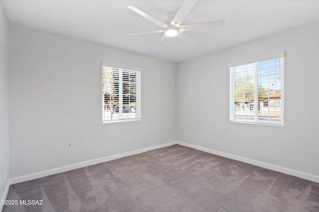 carpeted empty room featuring a ceiling fan and baseboards