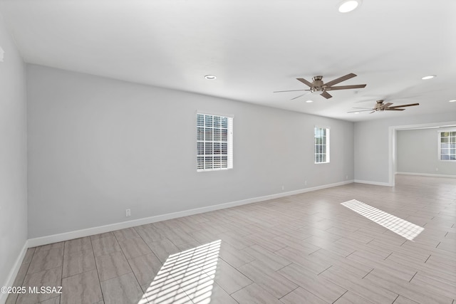 spare room featuring recessed lighting and baseboards