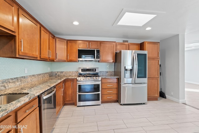 kitchen featuring tasteful backsplash, appliances with stainless steel finishes, and brown cabinets