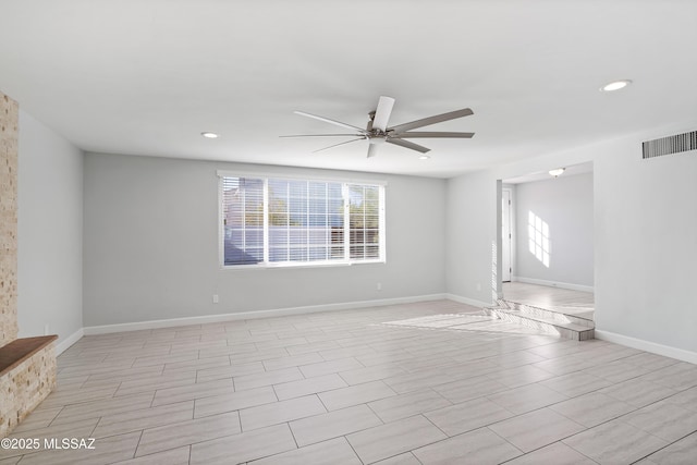 spare room featuring baseboards, plenty of natural light, visible vents, and a ceiling fan