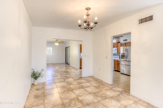 empty room with light tile patterned floors, visible vents, and ceiling fan with notable chandelier