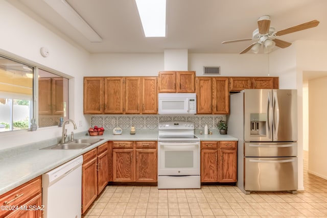 kitchen featuring white appliances, visible vents, backsplash, and a sink