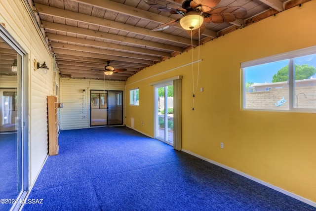 empty room featuring carpet, vaulted ceiling with beams, a ceiling fan, wooden ceiling, and baseboards