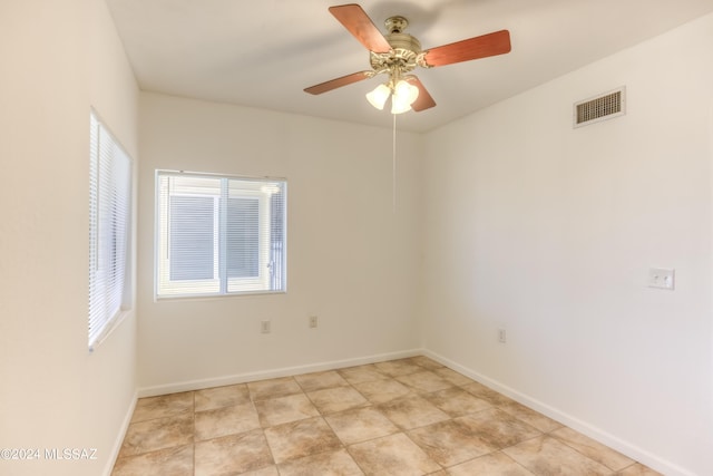 unfurnished room with baseboards, visible vents, and ceiling fan