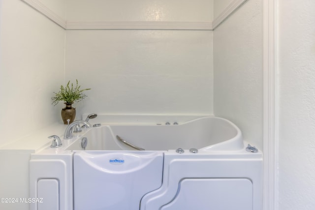 bathroom featuring a bath and a textured wall