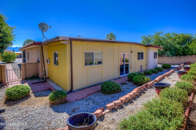 back of property with fence and a gate